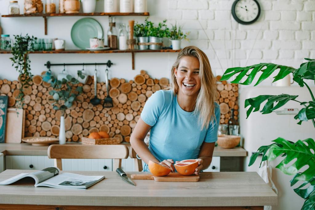Blonde Frau in einer offenen Küche, die gerade eine Grapefruit zerteilt. 